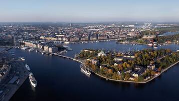 An aerial view of a city with a river, a bridge, and a small island with buildings and trees.