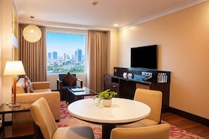 A hotel room with a city view, a round dining table with chairs, a TV, a desk with a lamp, and a plant. - Hilton Garden Inn New Delhi/Saket (New Delhi)