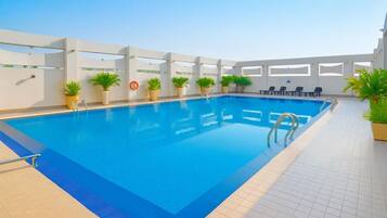 Una piscina al aire libre, tumbonas