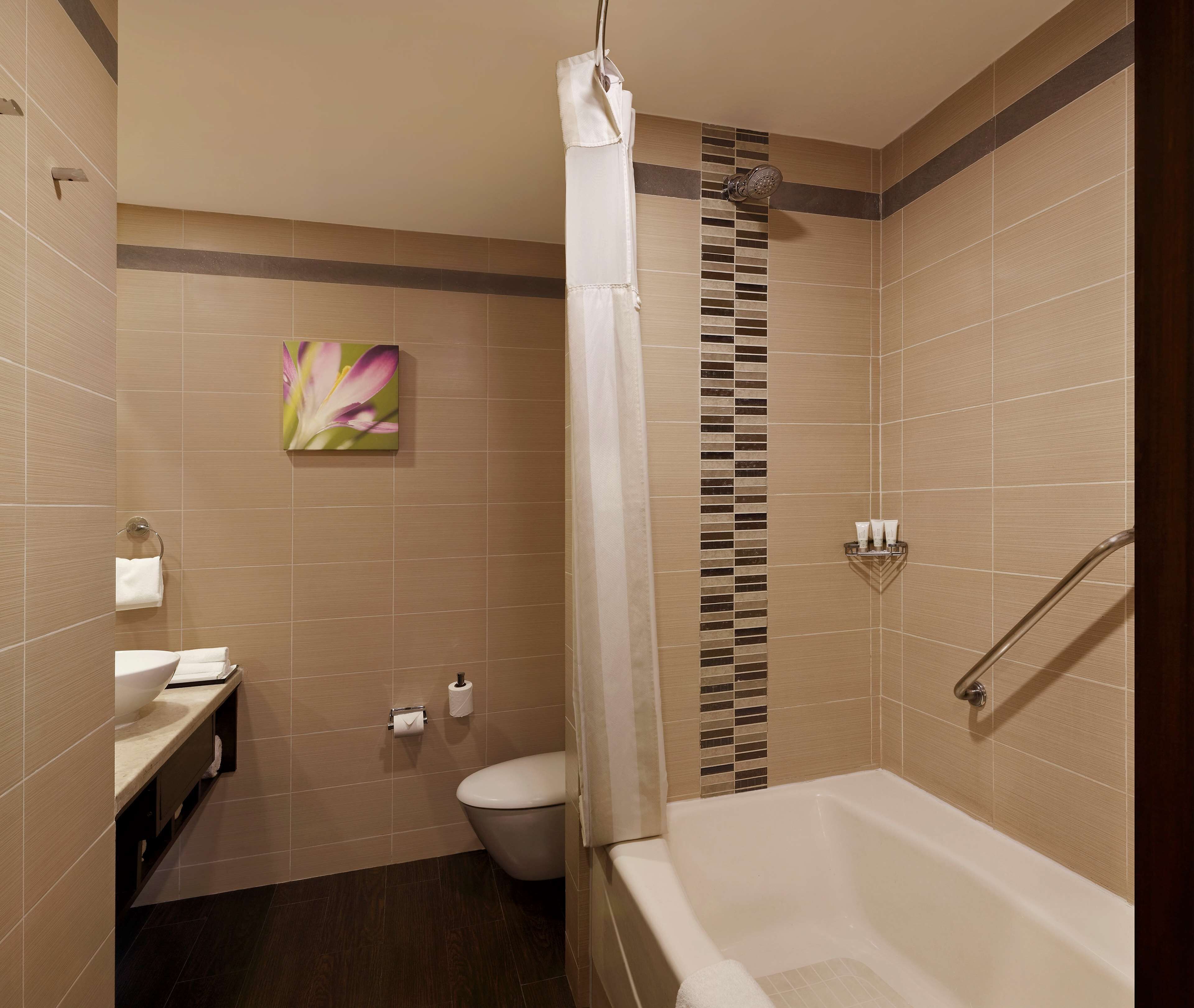 A modern bathroom with a bathtub, toilet, and sink.