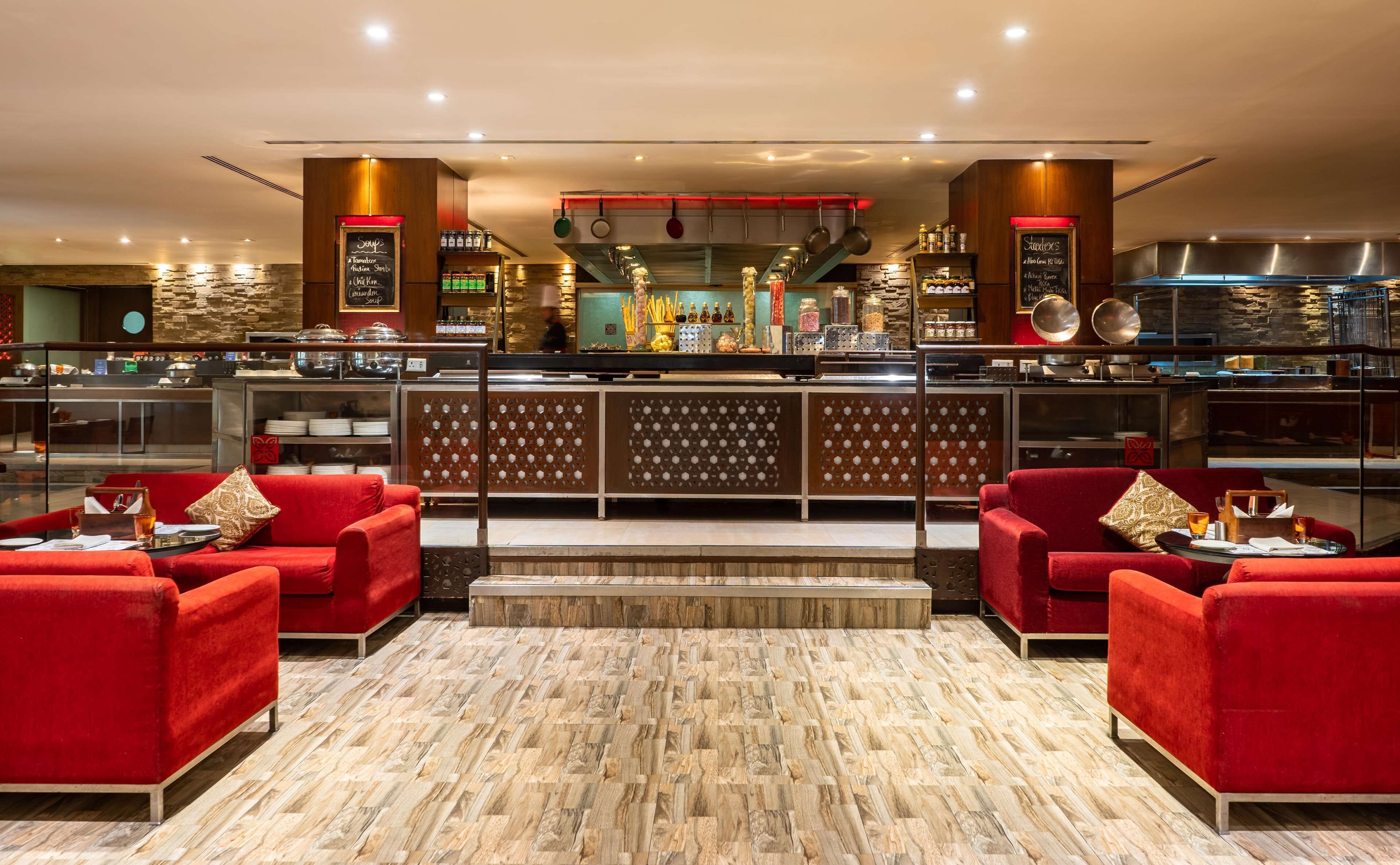 Un restaurant doté d’un bar, de canapés rouges et d’un plancher en bois.