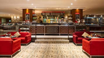 Un restaurant doté d’un bar, de canapés rouges et d’un plancher en bois.