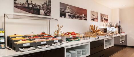 A buffet with various food items and a coffee station.