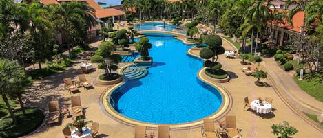 Una piscina al aire libre, sillones reclinables de piscina