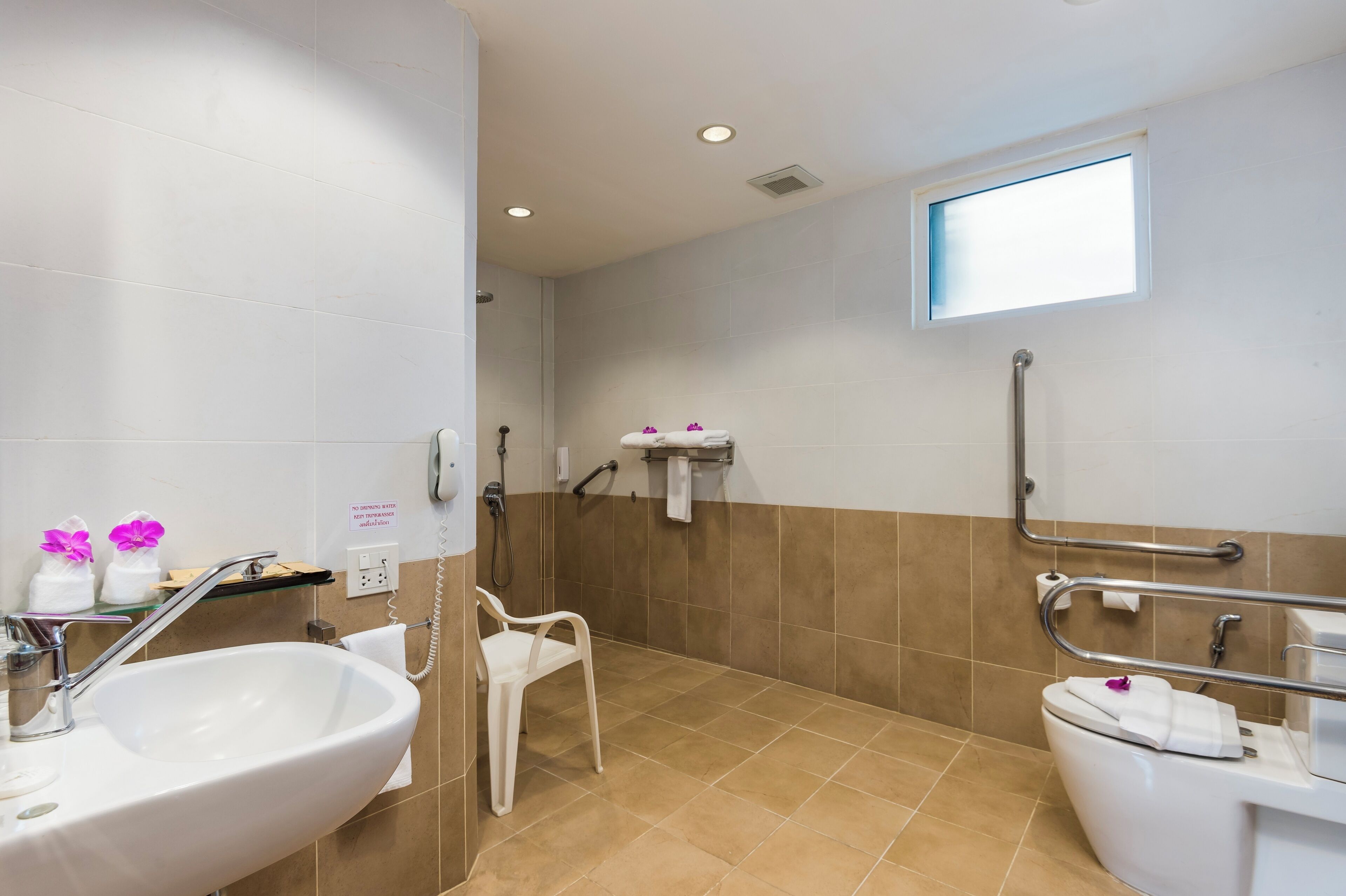 A modern bathroom with a sink, toilet, and shower.