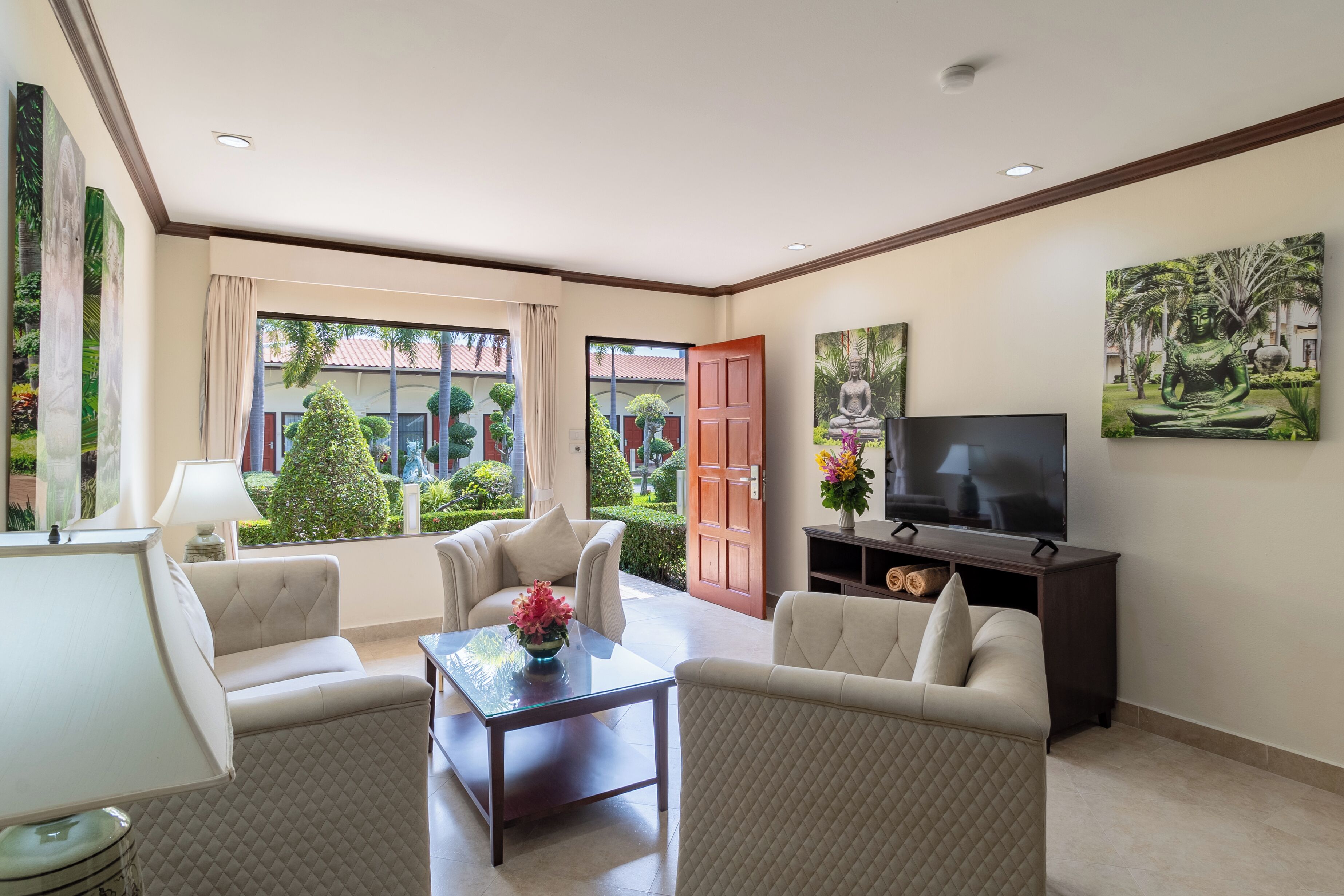 A modern living room with a sofa set, a coffee table, a TV, and artwork on the walls.