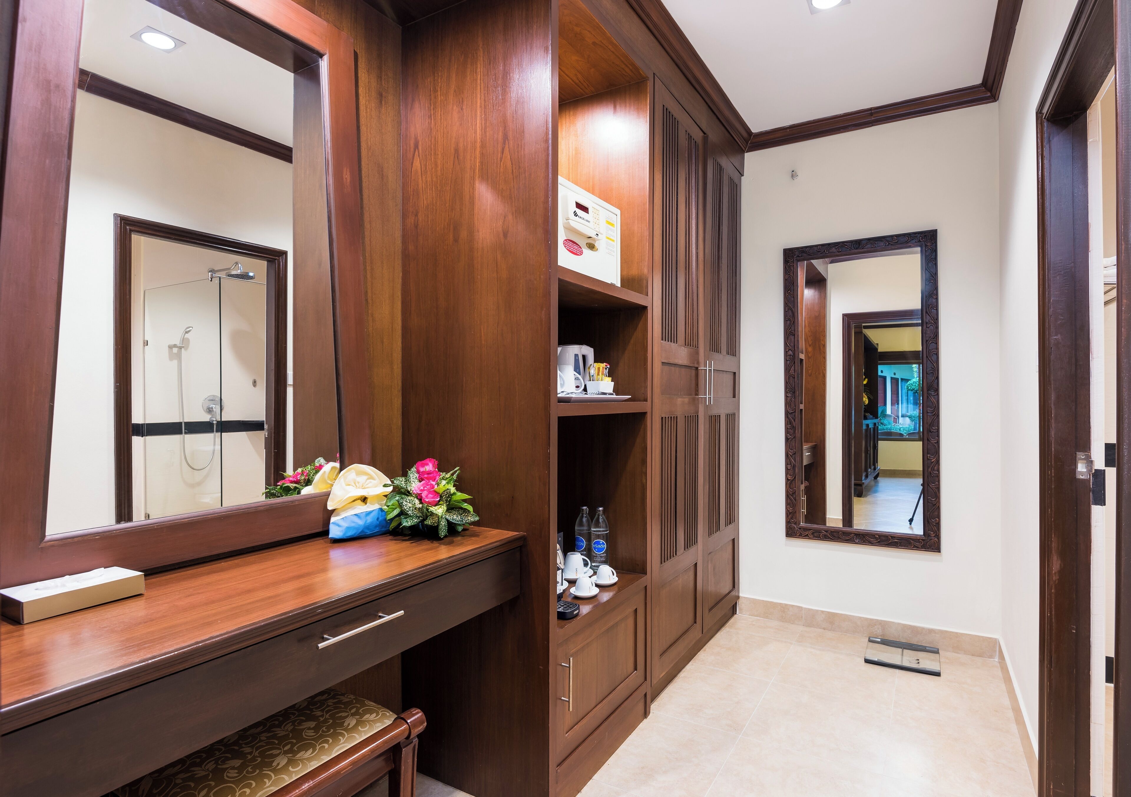 A bathroom with a wooden vanity, a mirror, a shower, and a toilet.