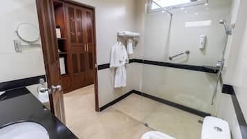 A modern bathroom with a glass-enclosed shower, a black countertop sink, and a white toilet.