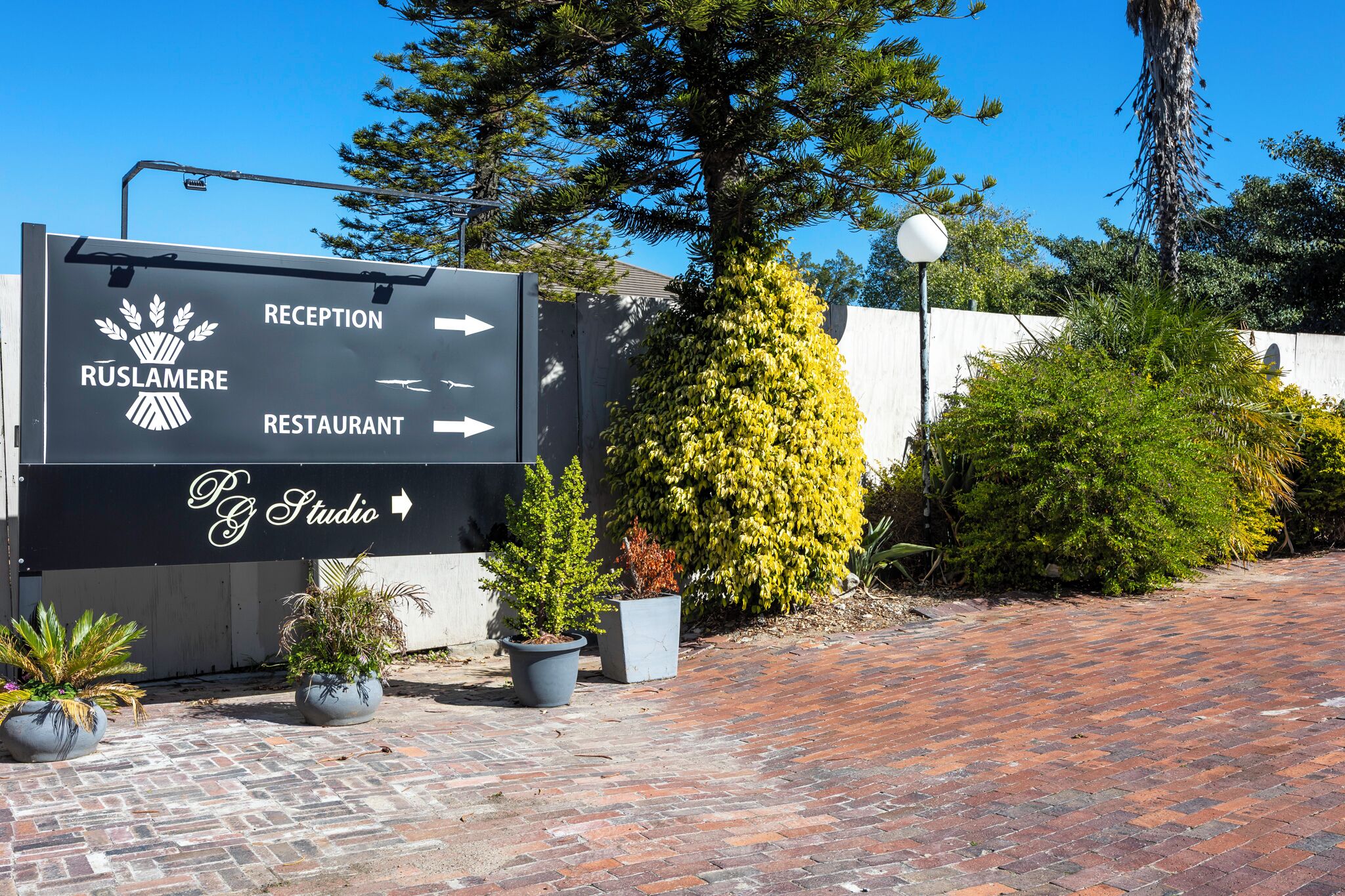 Señal de recepción con flechas indicando la dirección a recepción, restaurante y estudio.