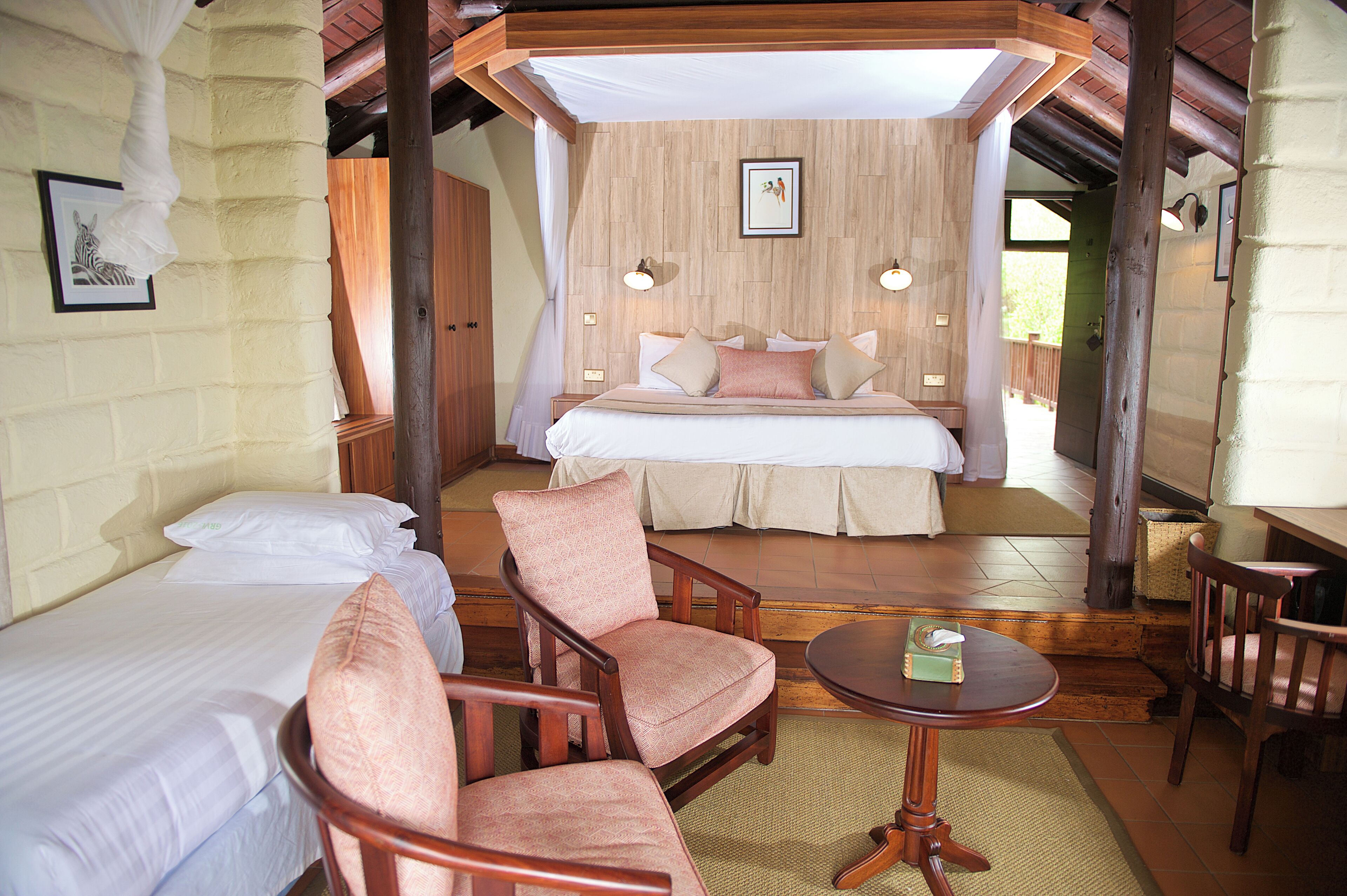 Une chambre à coucher avec un lit, deux chaises, une table et une table de chevet.