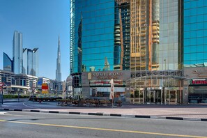 A modern hotel with a glass facade, a prominent entrance, and a view of the surrounding cityscape. - Number One Tower Suites (Dubai)