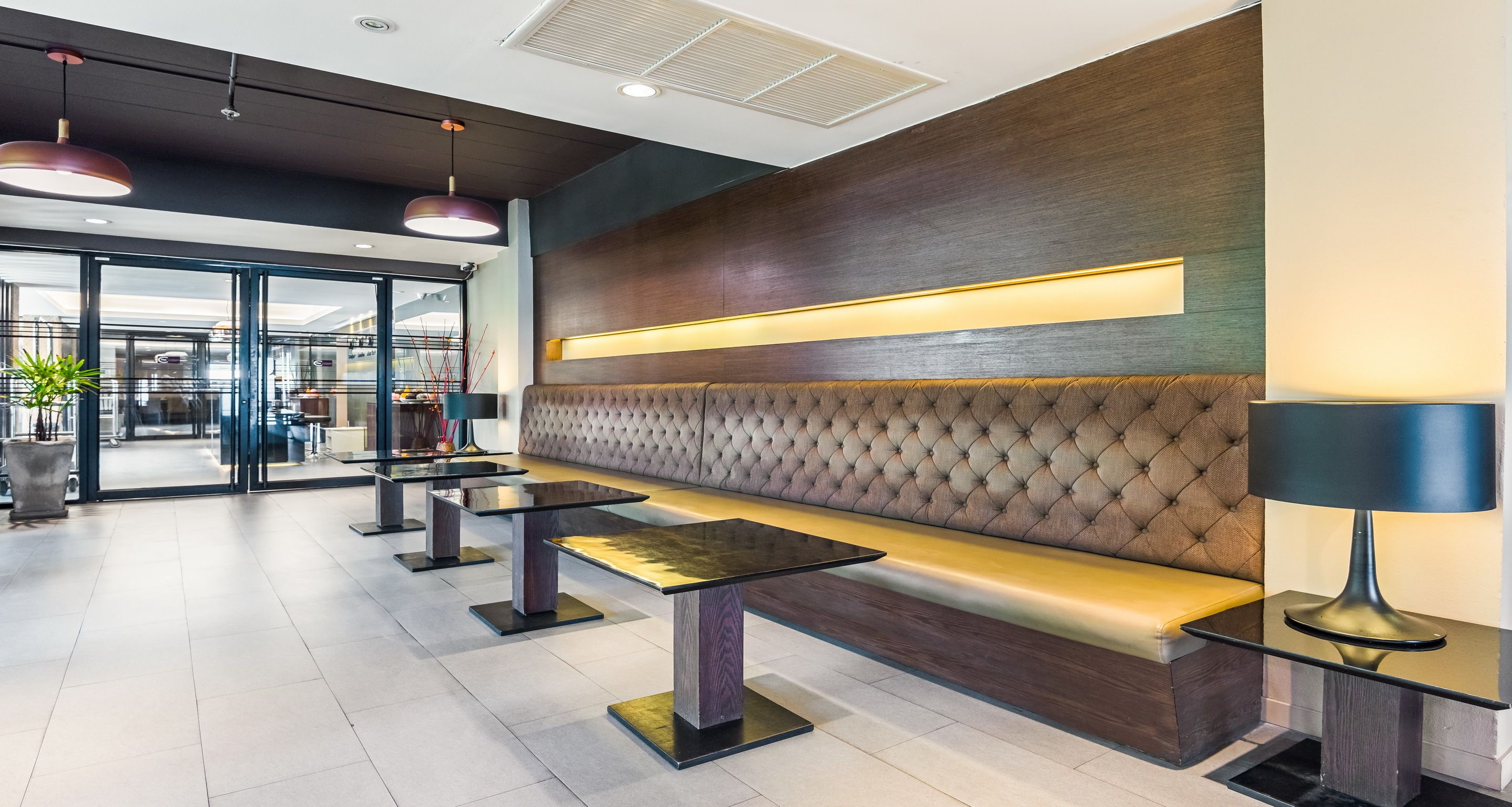 Eine moderne Lobby mit einer Sitzecke, ausgestattet mit einer gestopften Couch und Tischen.