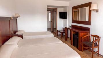 Une chambre d’hôtel avec deux lits, un bureau, une chaise, une télévision et un miroir.