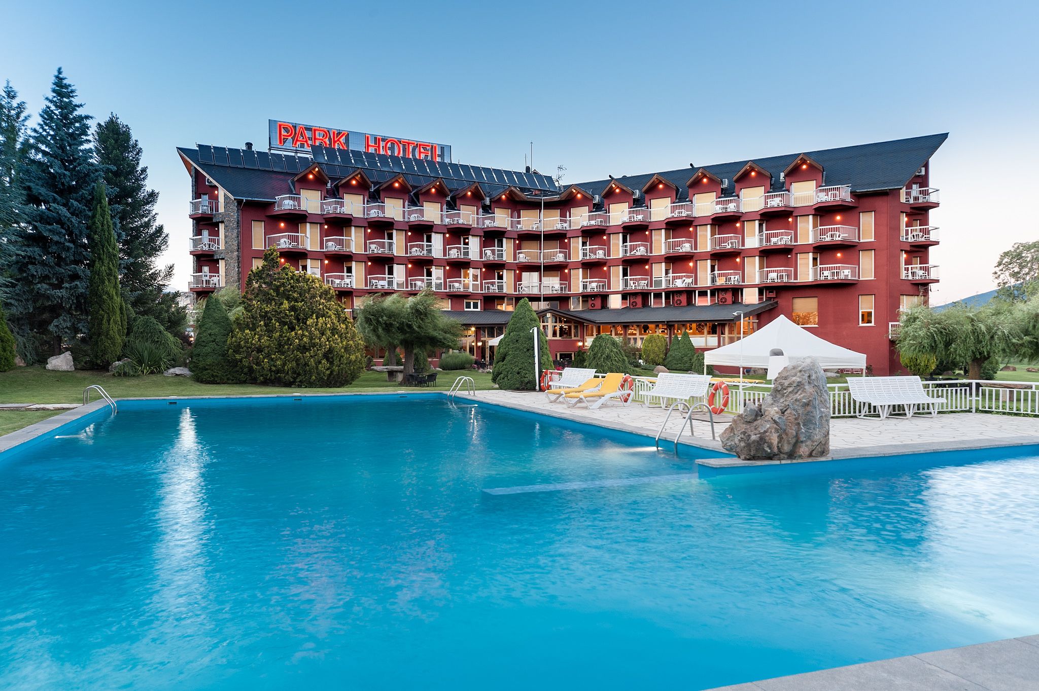 Una piscina al aire libre de temporada, sillones reclinables de piscina