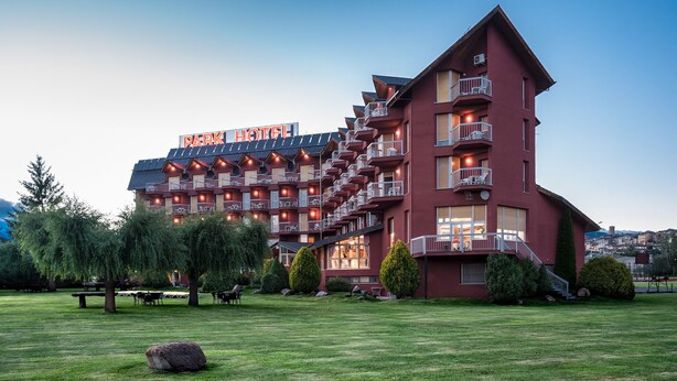 A multi-story hotel with a red facade, balconies, and a sign that reads "Park Hotel." - Park-Hotel (Puigcerda)