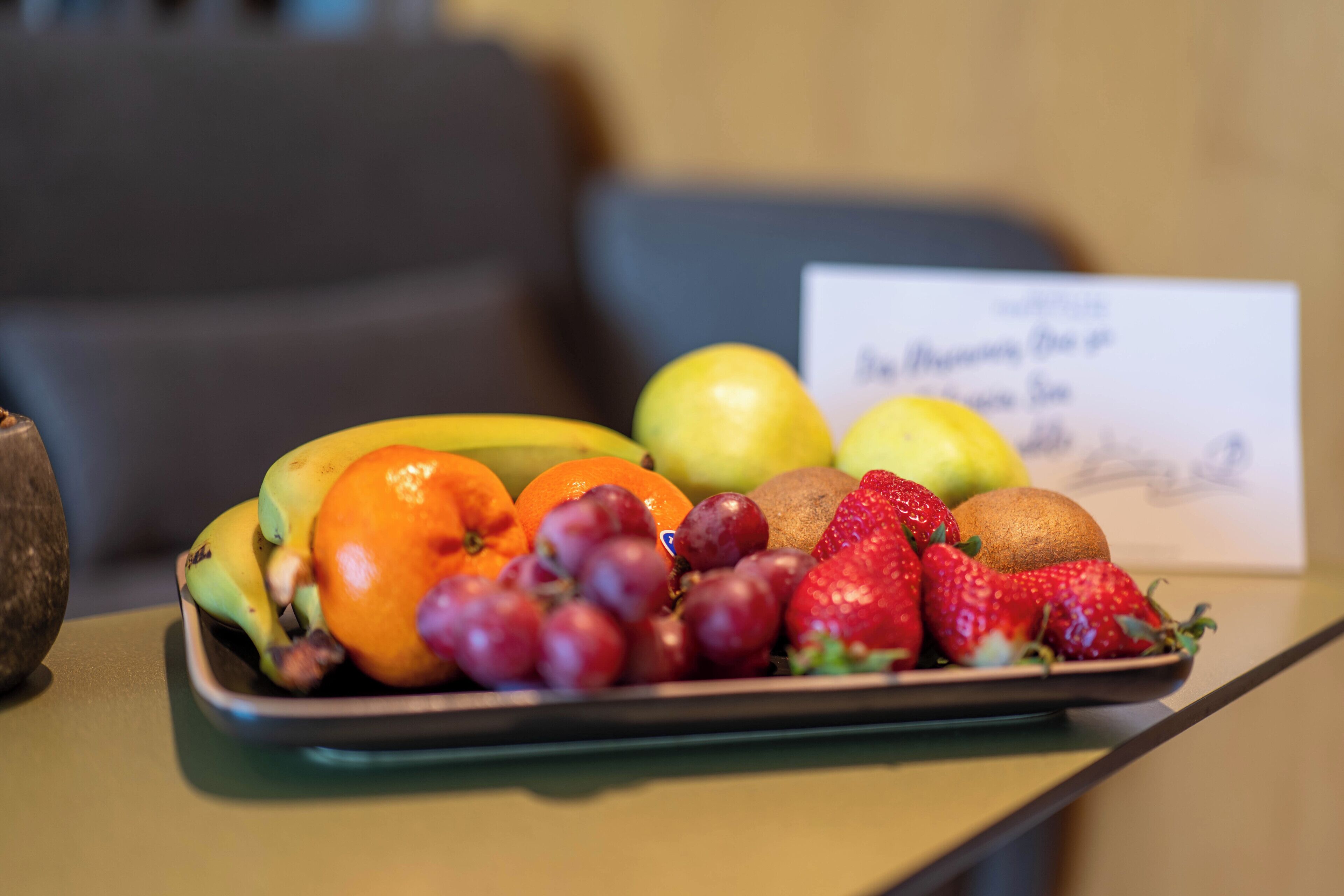 A fruit platter on a table with a sign in the background.