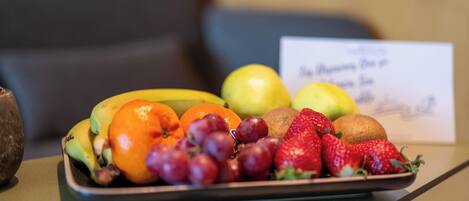 A fruit platter on a table with a sign in the background.