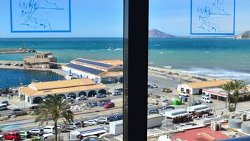 Vista desde una ventana con vistas a una zona costera donde se divisa un hotel llamado PORTO CALPE.