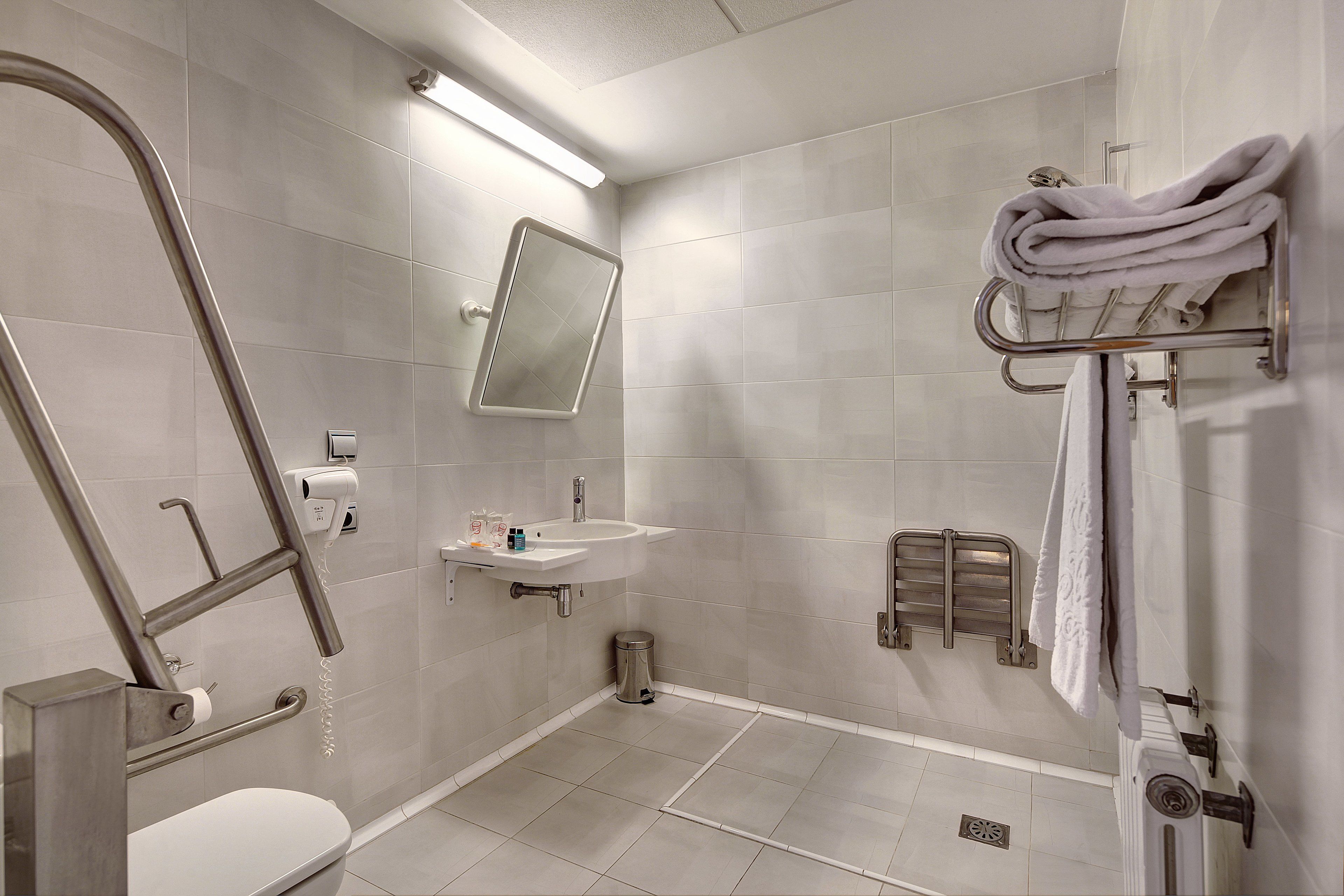 Un baño moderno con inodoro, lavamanos y zona de ducha.