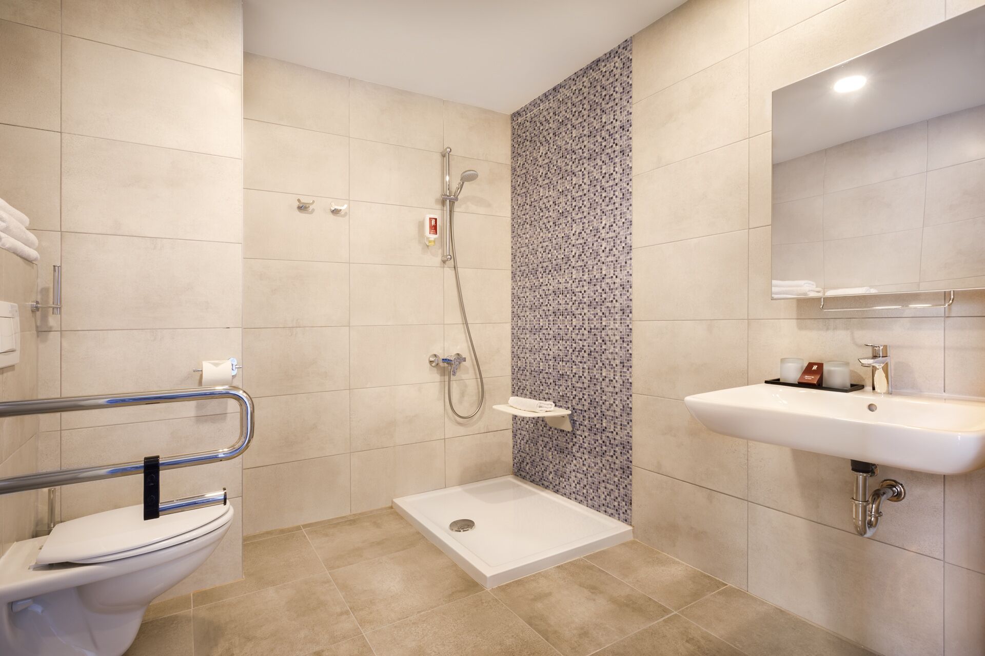 A modern bathroom with a shower, toilet, and sink.