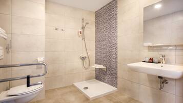 A modern bathroom with a shower, toilet, and sink.
