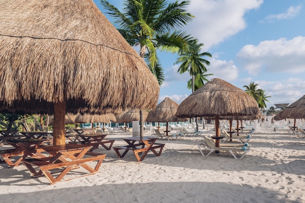 On the beach, white sand, sun loungers, beach umbrellas