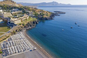 On the beach, black sand, sun loungers, beach umbrellas