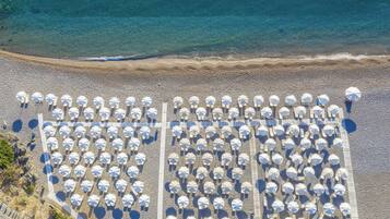On the beach, black sand, sun-loungers, beach umbrellas