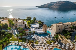 A resort with a large pool, outdoor seating, and a view of the sea. - Lindos Royal Resort - All Inclusive (Rhodes)