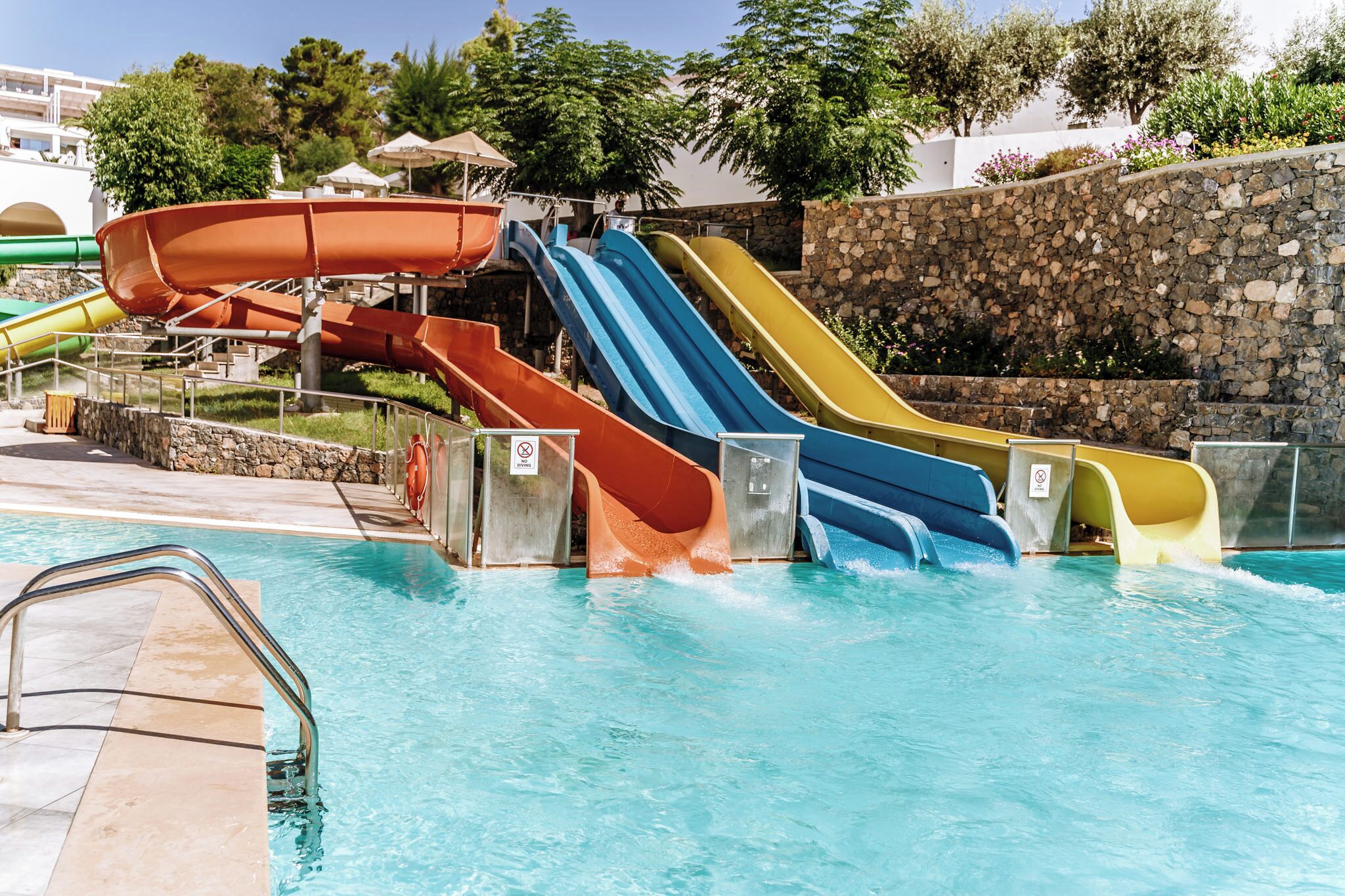 A water park with multiple slides and a swimming pool.