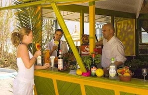 A bar area with a counter, bottles, and fruits. - Iberostar El Fatimi (Mahdia)