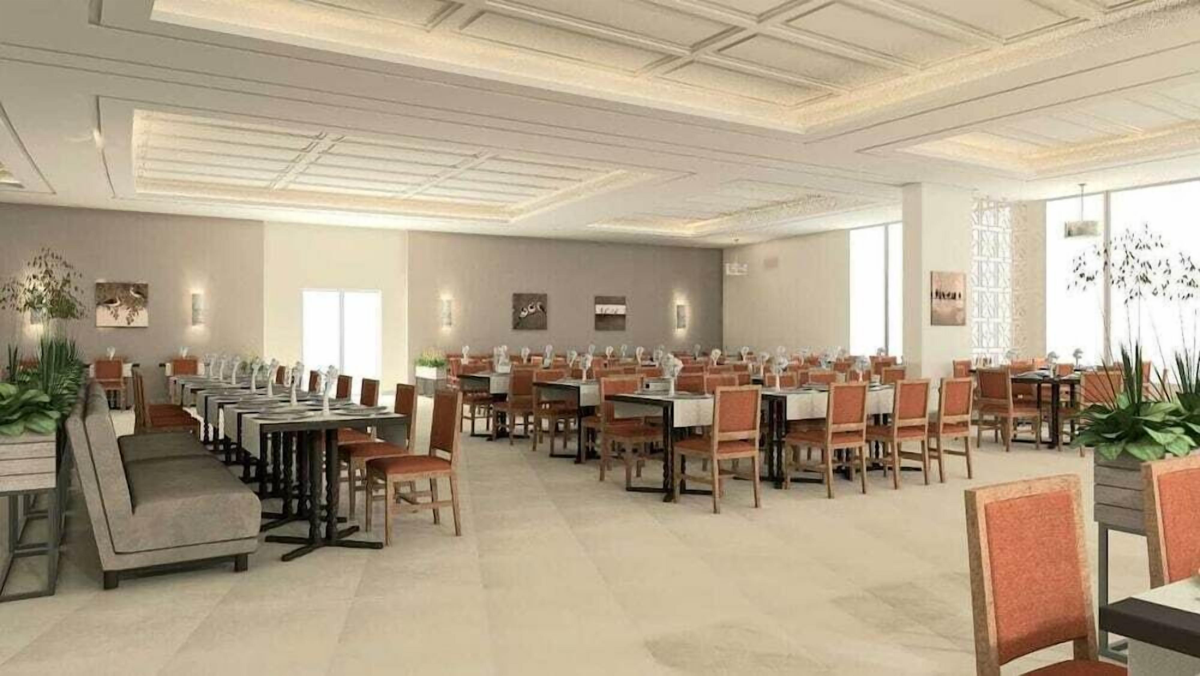 A spacious dining area with multiple tables and chairs, arranged in rows.