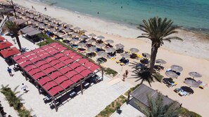 A beachside resort with sun loungers, umbrellas, and a covered seating area. - Vincci Safira Palms (Zarzis)