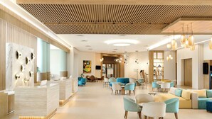 A spacious lobby with a reception desk, seating area, and modern lighting fixtures. - Iberostar Waves Mehari Djerba (Djerba Midun)