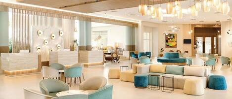Una hall moderna di un hotel, con una reception, zone relax e un'ampia opera d'arte a parete.