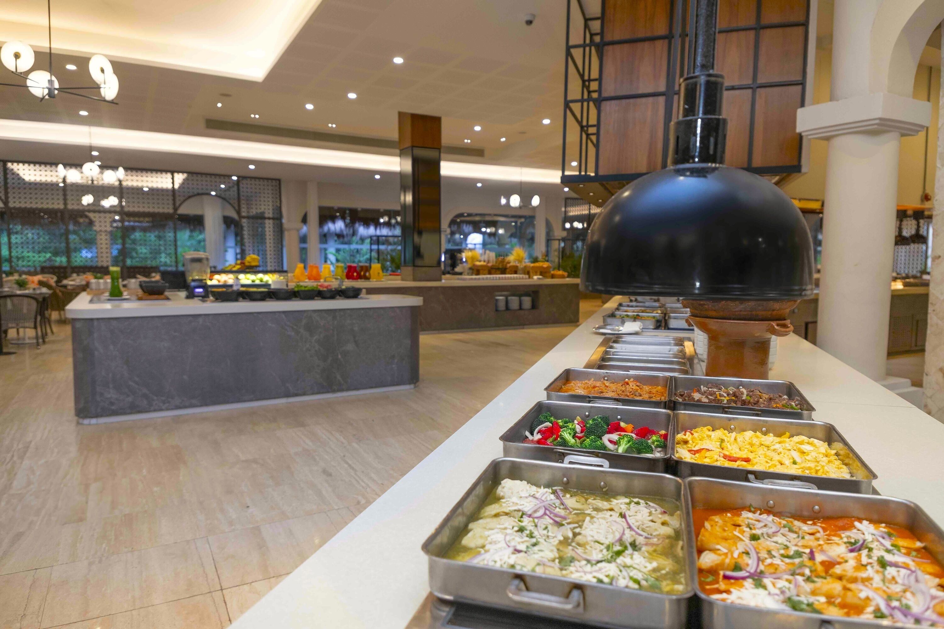 A buffet with various food options, a central island, and a large black dome structure.