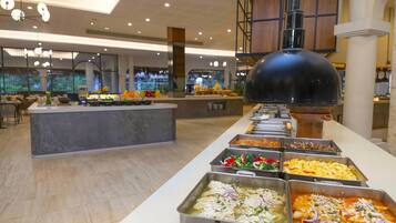 A buffet with various food options, a central island, and a large black dome structure.