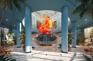 A spacious lobby with a central fountain, palm trees, and a large sculpture. - JOIA Rose Hall by Iberostar - Adults Only - All Inclusive (Montego Bay)