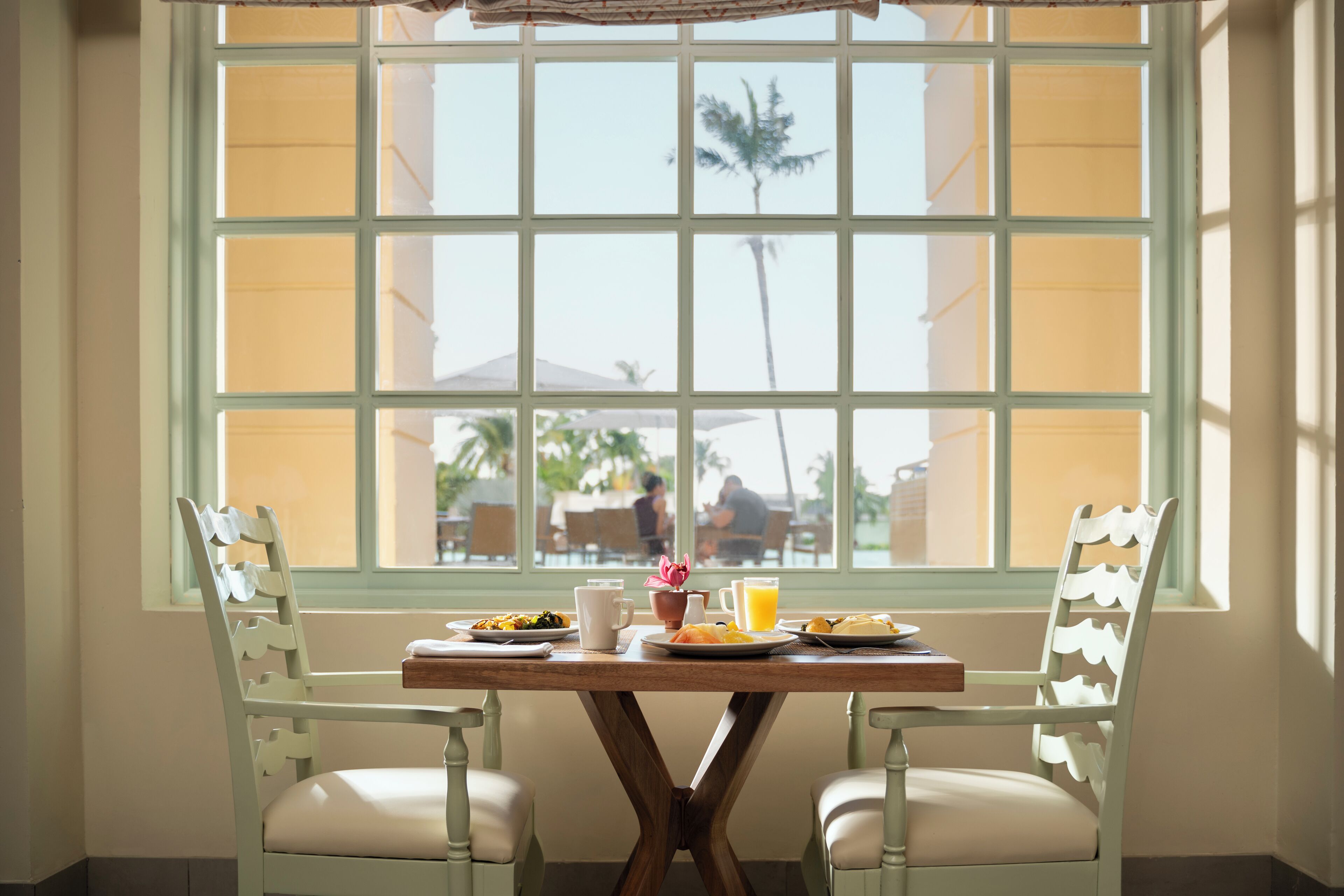 A dining table with chairs and breakfast items.