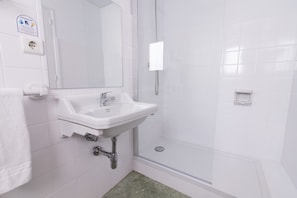 A bathroom with a white sink, a mirror, a glass shower enclosure, and a white towel on the wall. - Azuline Hotel S'anfora & Fleming (Sant Antoni de Portmany)