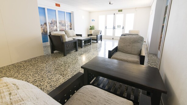 Un hall d’entrée avec des sièges, une table basse et une plante en pot.