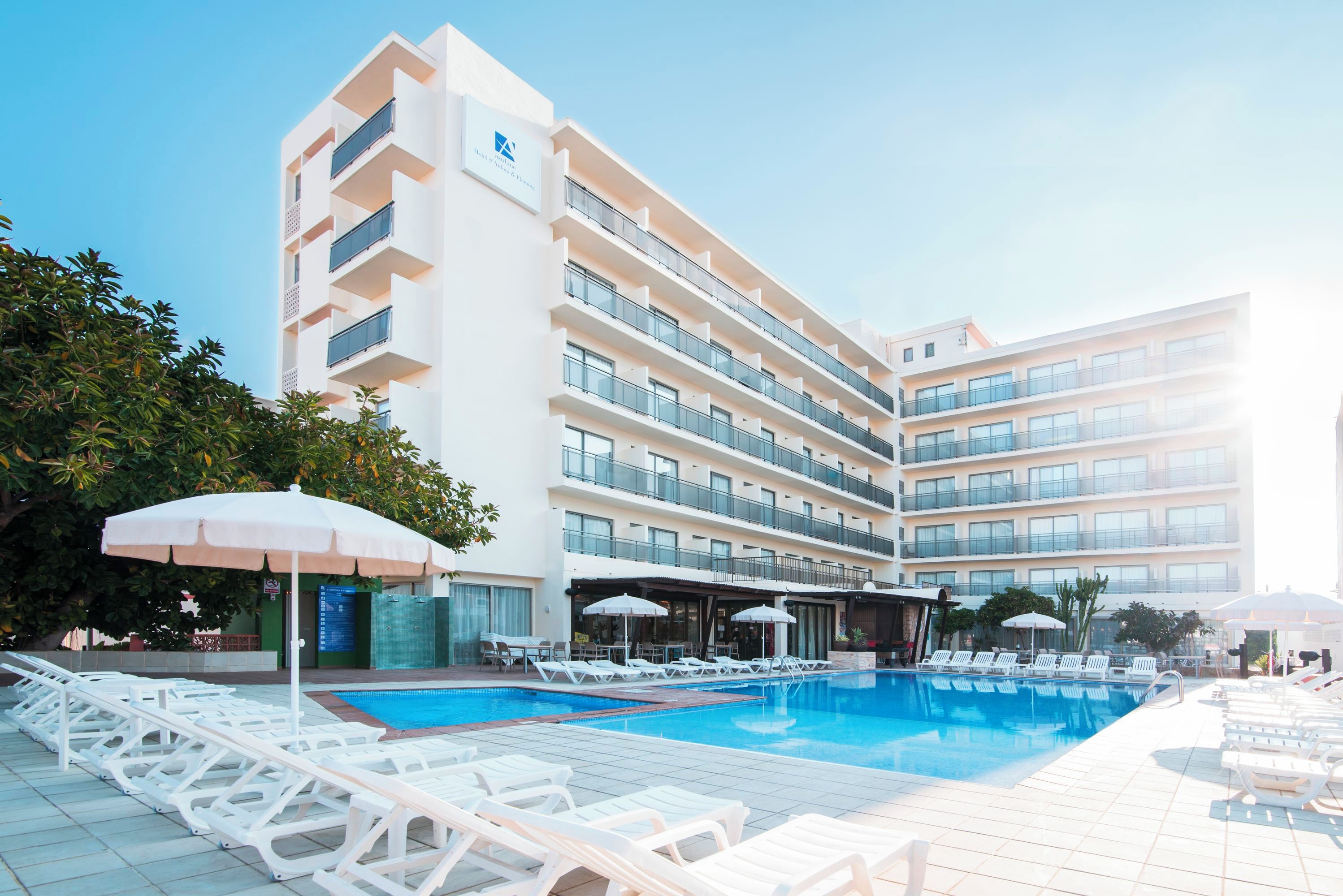 Un hôtel doté d’une piscine, de plusieurs balcons et de chaises longues.
