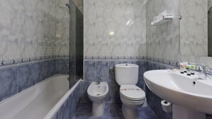 Une salle de bain équipée d’une baignoire, d’un bidet, de toilettes et d’un lavabo.