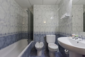 A bathroom with a bathtub, a bidet, a toilet, and a sink. - Azuline Hotel S'anfora & Fleming (Sant Antoni de Portmany)
