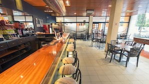 A restaurant interior with a long bar, multiple seating areas, and a variety of food and drink items on display. - azuLine Hotel Pacific (Sant Antoni de Portmany)