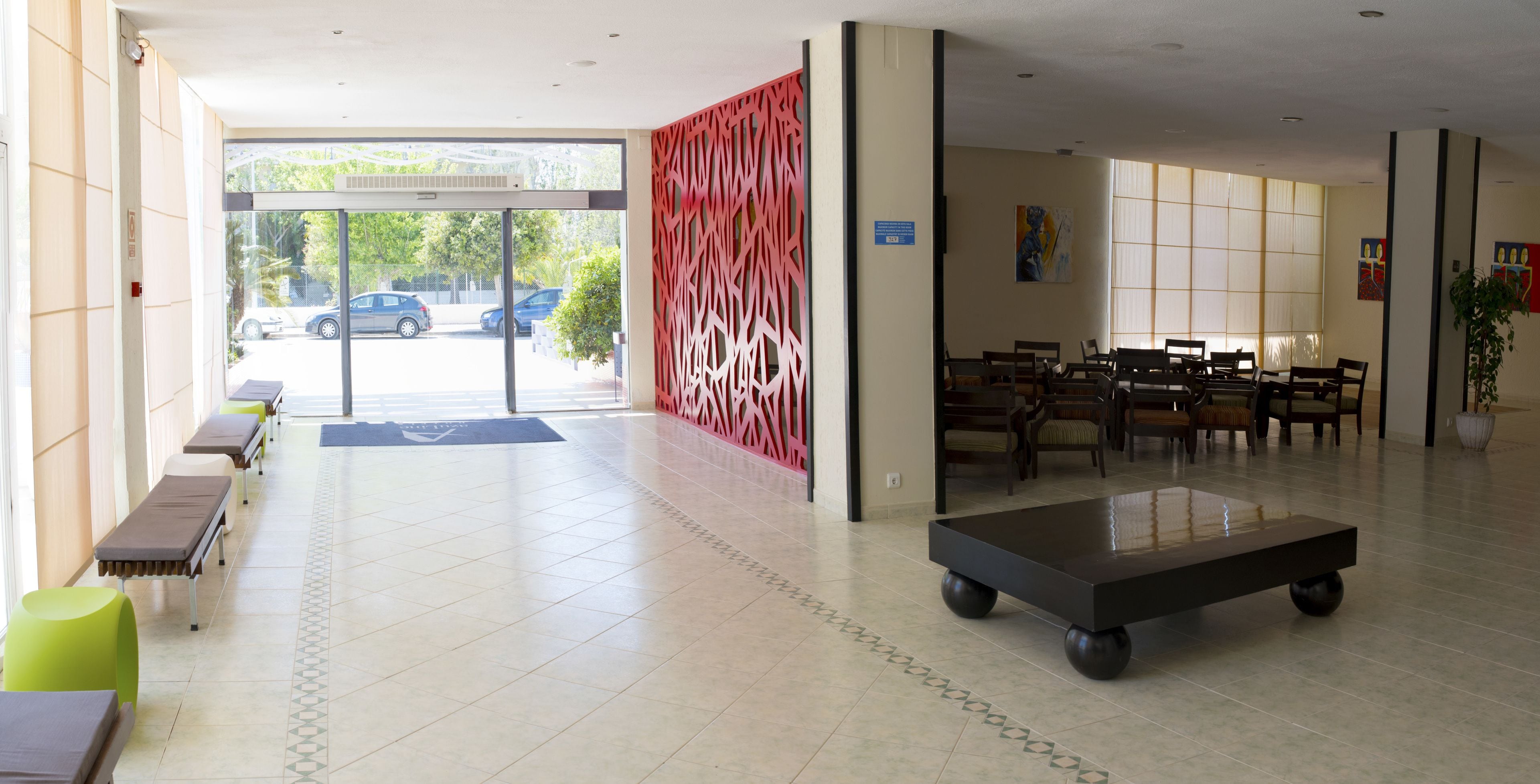 Un vestíbulo amplio con mostrador de recepción, zona de estar y una mesa grande.