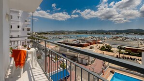 Ein Balkon mit Blick auf einen Yachthafen, Gebäude und Berge.