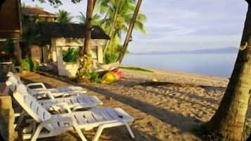 On the beach, white sand, sun-loungers, beach umbrellas