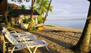 On the beach, white sand, sun-loungers, beach umbrellas