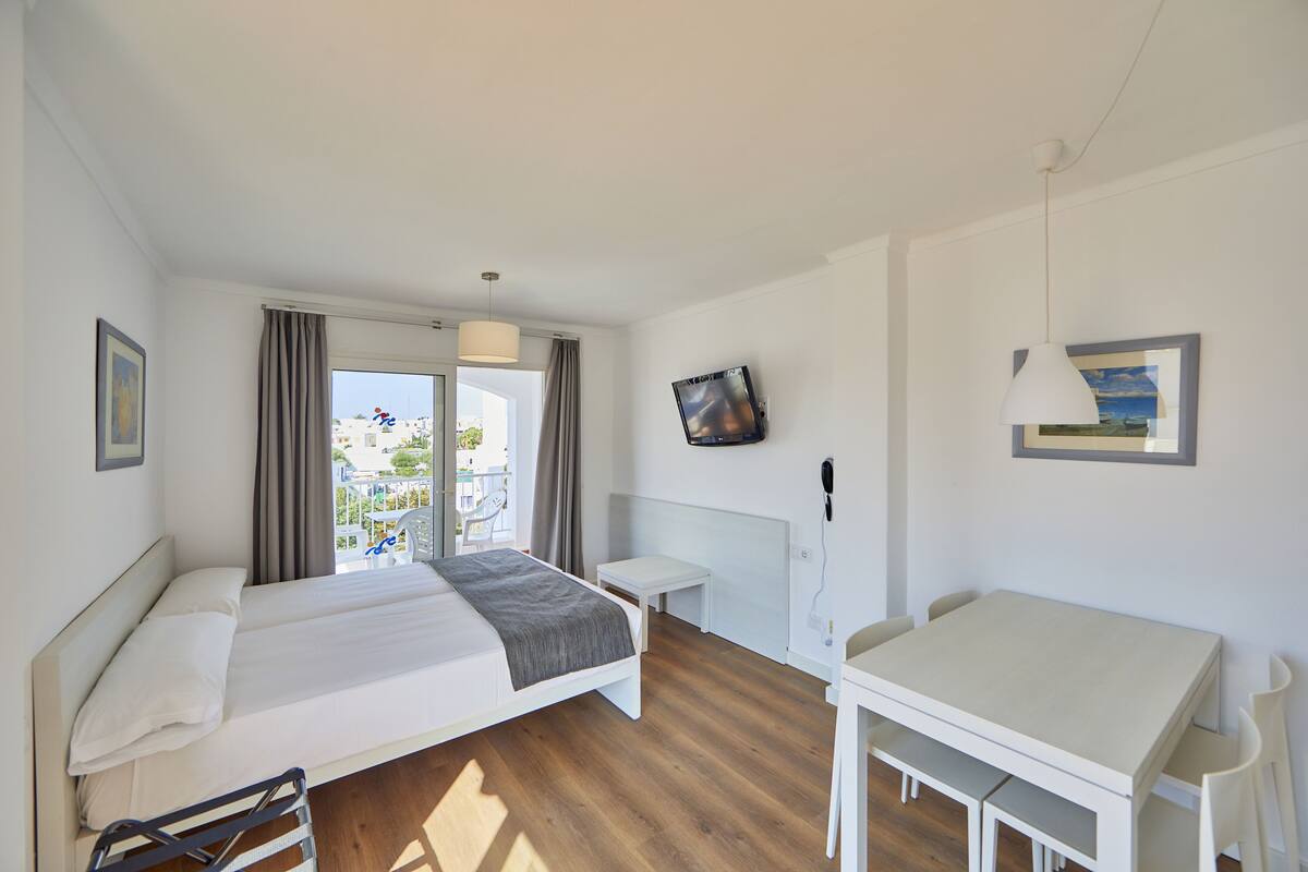 Habitación de hotel moderna con una cama grande, un escritorio y vistas al exterior.